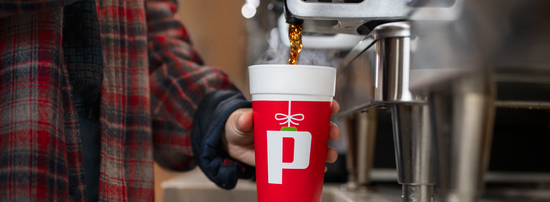 Person pouring coffee into Pilot Holiday cup